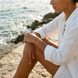 Riviera Bold chain bracelet in gold-plated stainless steel on a wrist, seaside lifestyle view