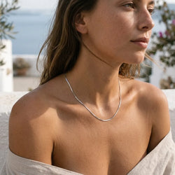 Minimal Siena silver snake chain necklace worn on collarbone
