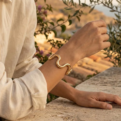 Waves open cuff gold bracelet worn on the wrist